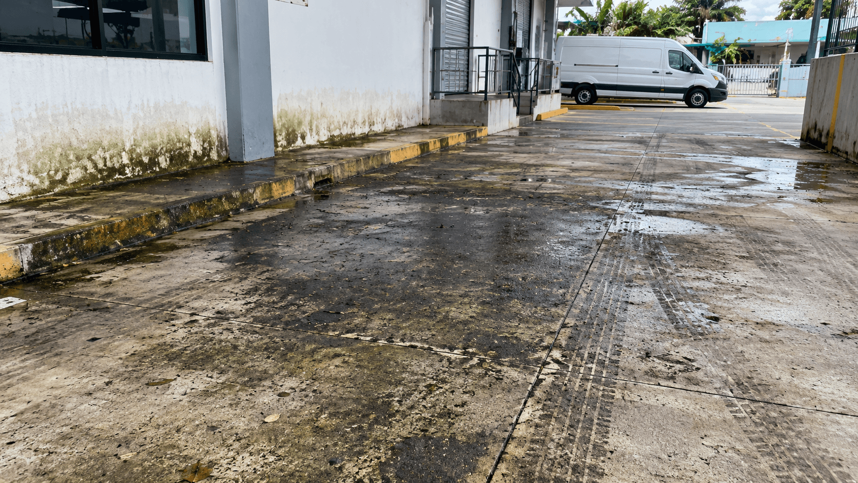 Acceso y pavimento de concreto con manchas de grasa, hongos y suciedad antes del lavado a presión